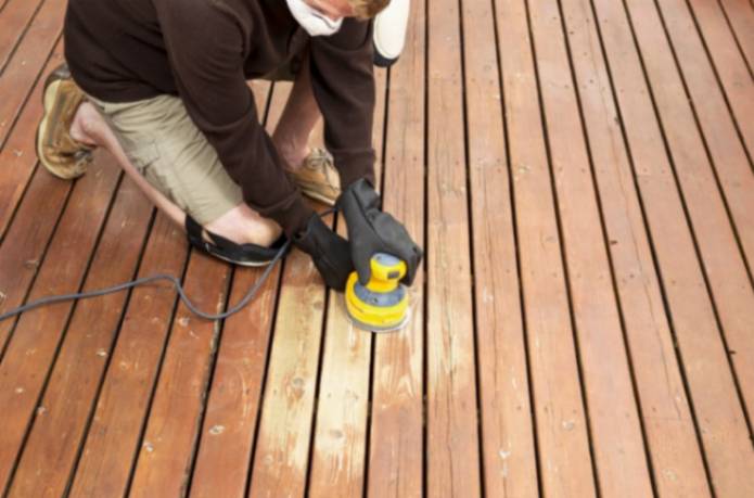 man doing decking repair and refinishing