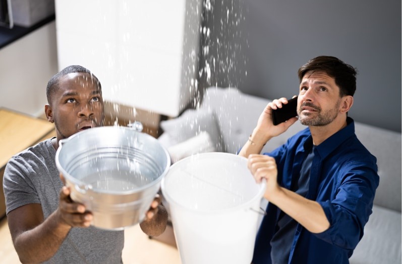 people holding buckets during a roof leak