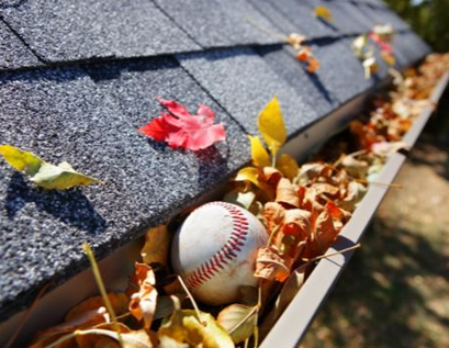 Ball in rain gutter needing gutter maintenance services