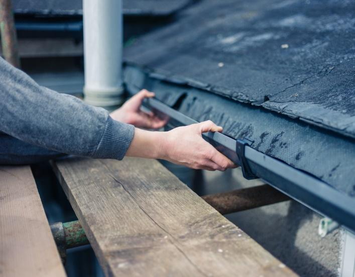 Man working on rain gutter repair